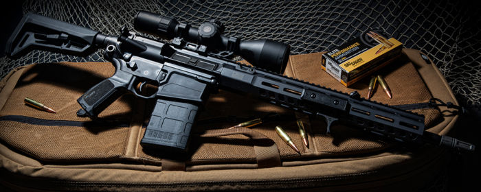 Direct Impingement 716i TREAD AR-10 Rifle on its rifle bag with a box of SIG SAUER ELITE HUNTER TIPPED ammunition