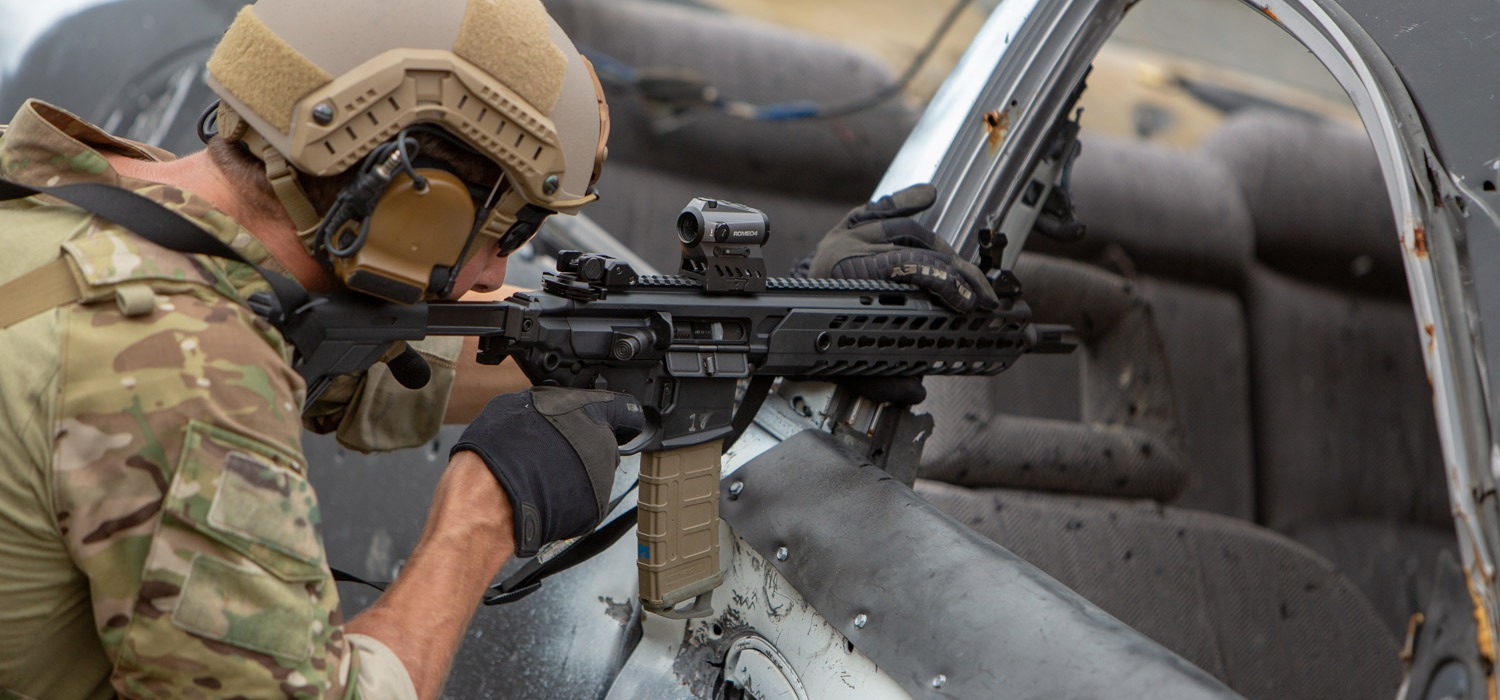 Shooter in tactical gear handles rifle in a vehicle at SIG SAUER Academy's extensive training environmnet. 